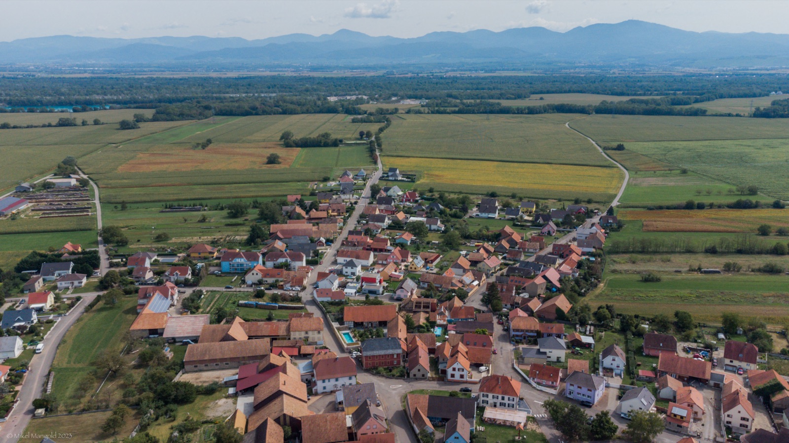 Aerial view of a village near Chalampé, with the Vosges mountains behind